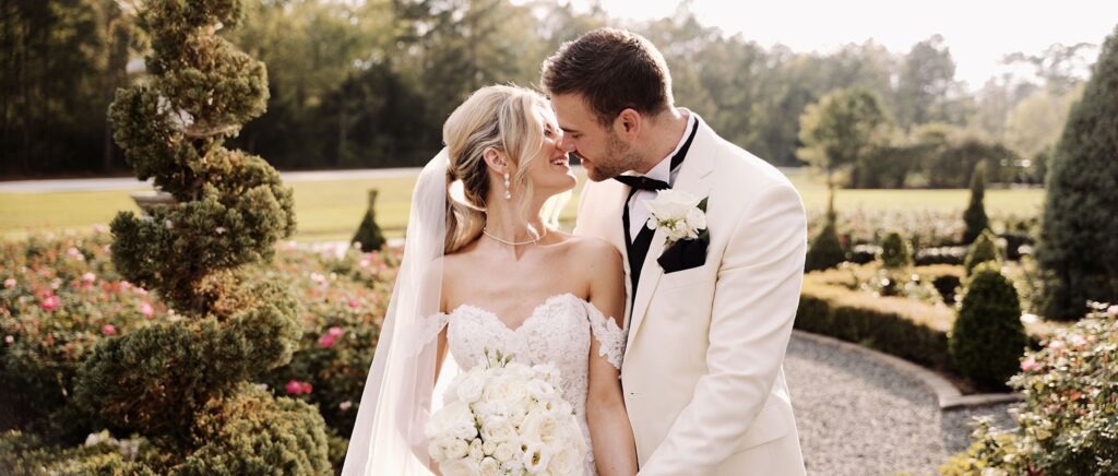 Bride and groom sharing a kiss at their wedding venue in Dallas, Texas, surrounded by elegant décor and wedding details.