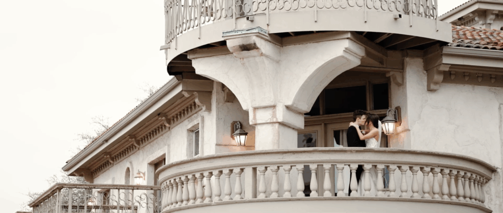 Bride and groom on the balcony of an esquisite architectural building in Houston, TX.