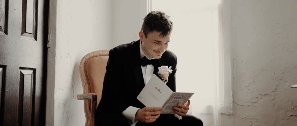 Groom reading a heartfelt letter from his bride before the wedding, showing his emotional reaction and anticipation.