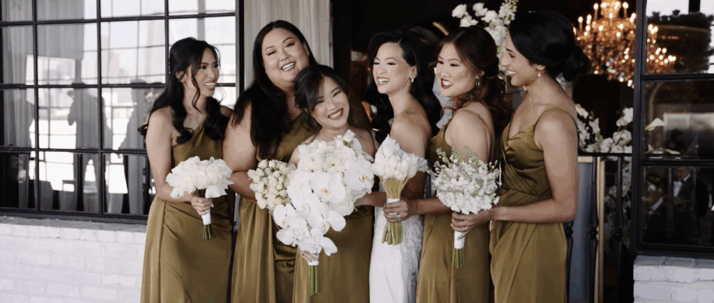 The bride and her bridesmaids are laughing and posing inside a wedding hall in Houston, TX.