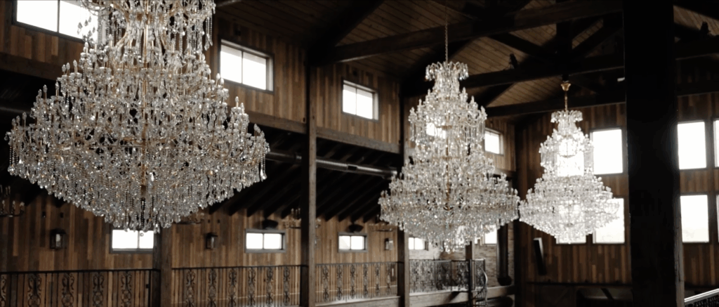 Elegant chandeliers hanging from a rustic wedding venue in Dallas.
