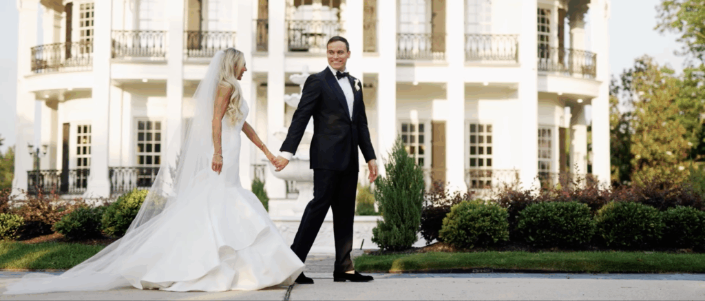 Couple holding hands in front of a beautiful outdoor wedding venue in Houston, TX.