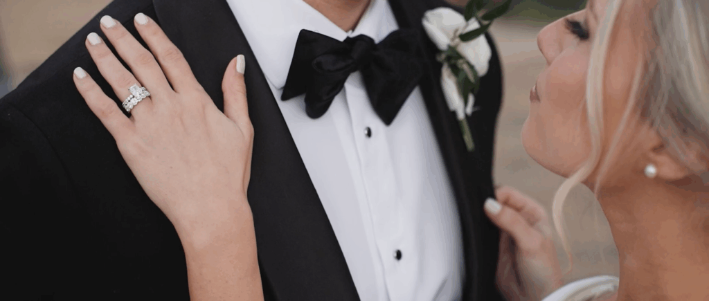 Bride leans into her groom in this tight shot at their wedding in Dallas.