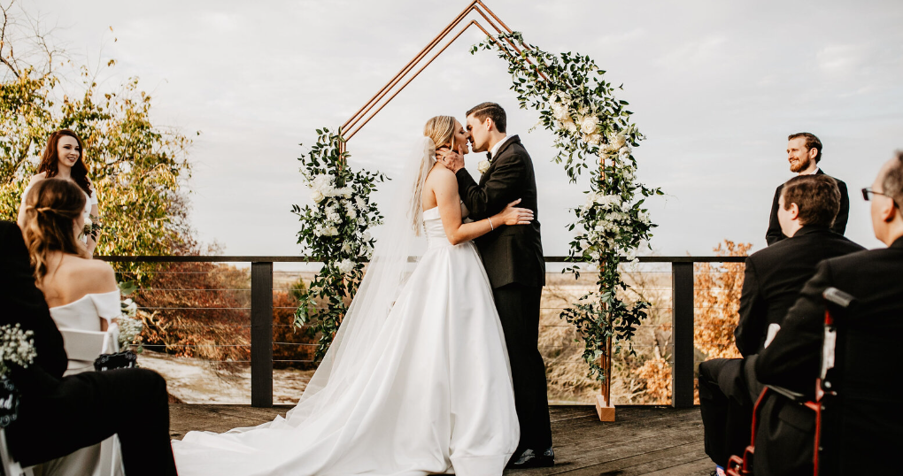Bride and groom exchanging vows outdoors at Bethel Rock wedding venue, surrounded by natural scenery and guests watching the ceremony.