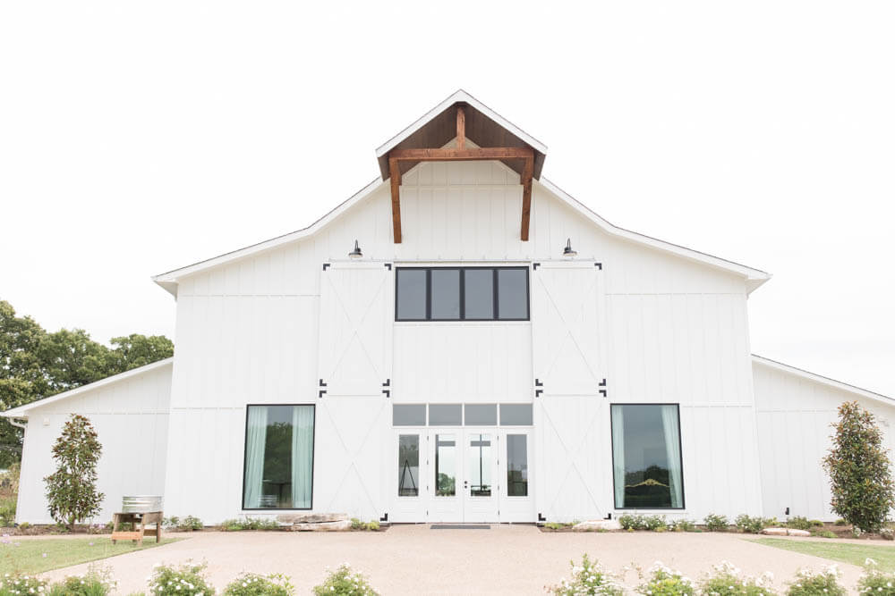 Exterior view of Chandelier Farms wedding venue in Texas, featuring a rustic barn-style building, elegant lighting, and scenic countryside surroundings.