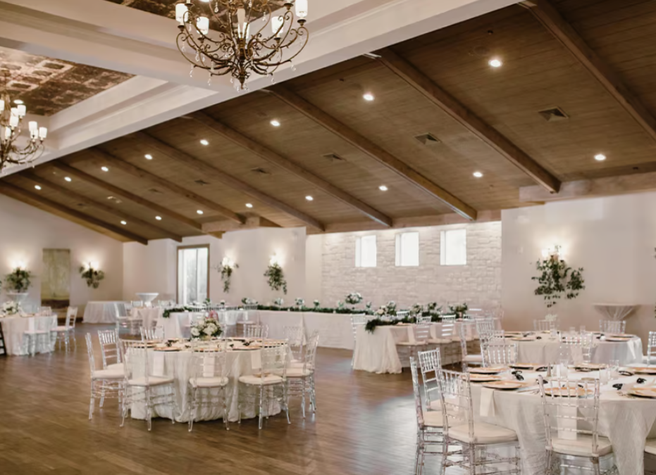 Interior of Hidden Pines wedding venue, featuring tables and chairs arranged for a reception, rustic décor with wooden beams, and ambient lighting.