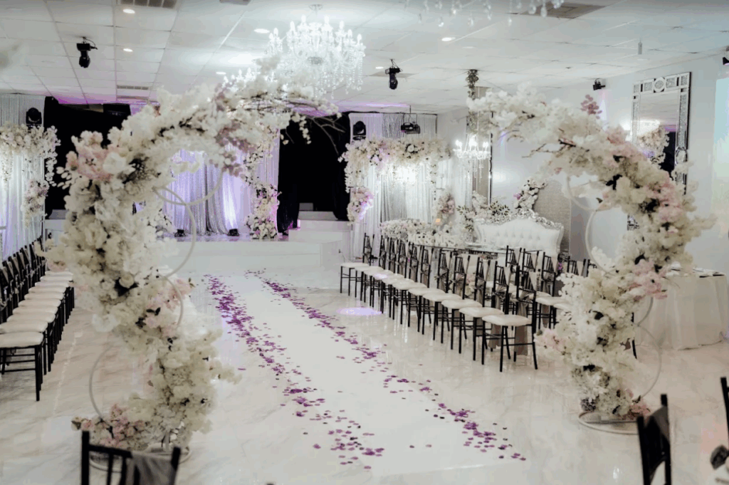 Interior of Superimperial Hall in Houston, Texas, showcasing lavish floral installations surrounding the room, with blooms lining tables, walls, and décor for an elegant event setting.