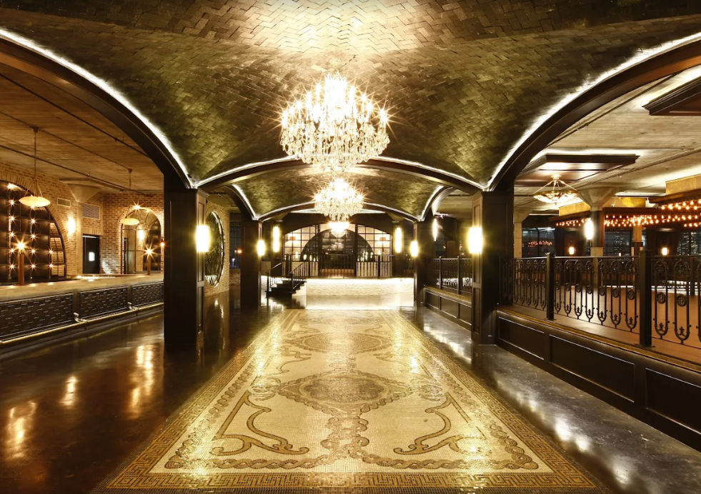 Indoor space at the Astorian in Houston, TX, with moody lighting and dark wood accents.