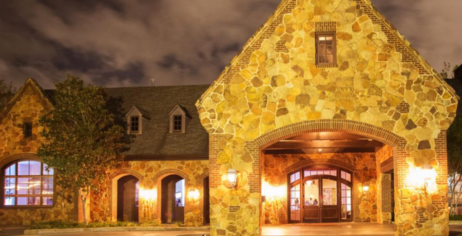 Exterior view of The Wynden wedding venue in Houston, Texas, featuring elegant architecture, lush greenery, and outdoor event space.