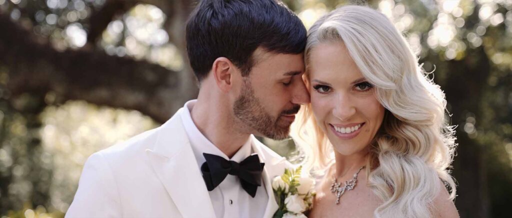 Groom leans in to hug his bride as she smiles ahead after their wedding in Houston, TX.