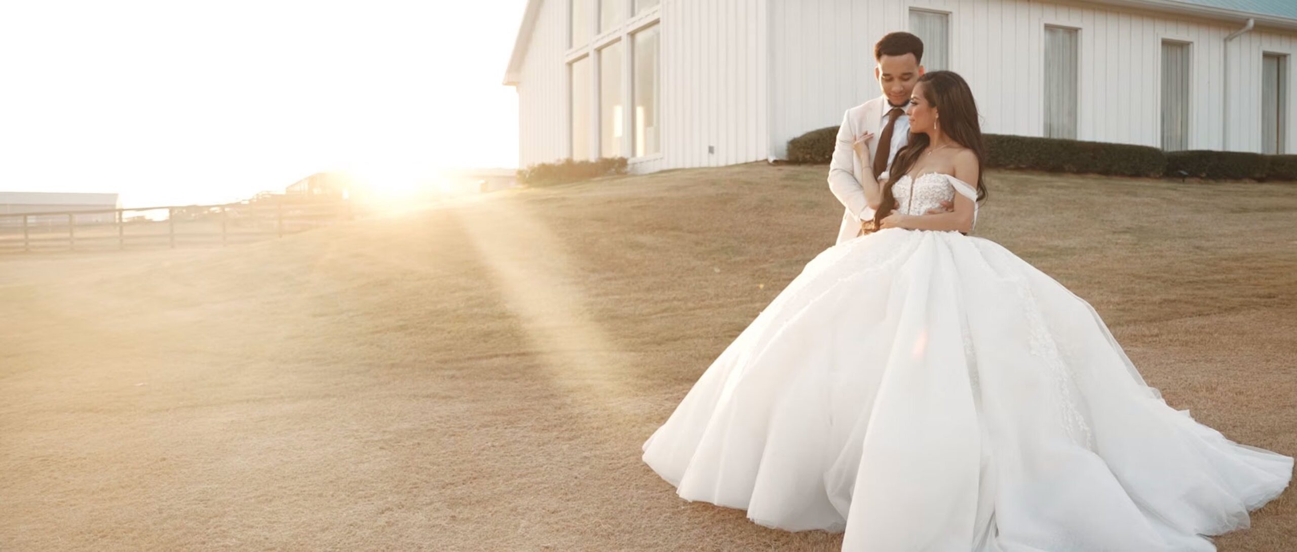 Newly married couple standing in front of a rustic barn in Houston, Texas, smiling and holding hands after their wedding ceremony.